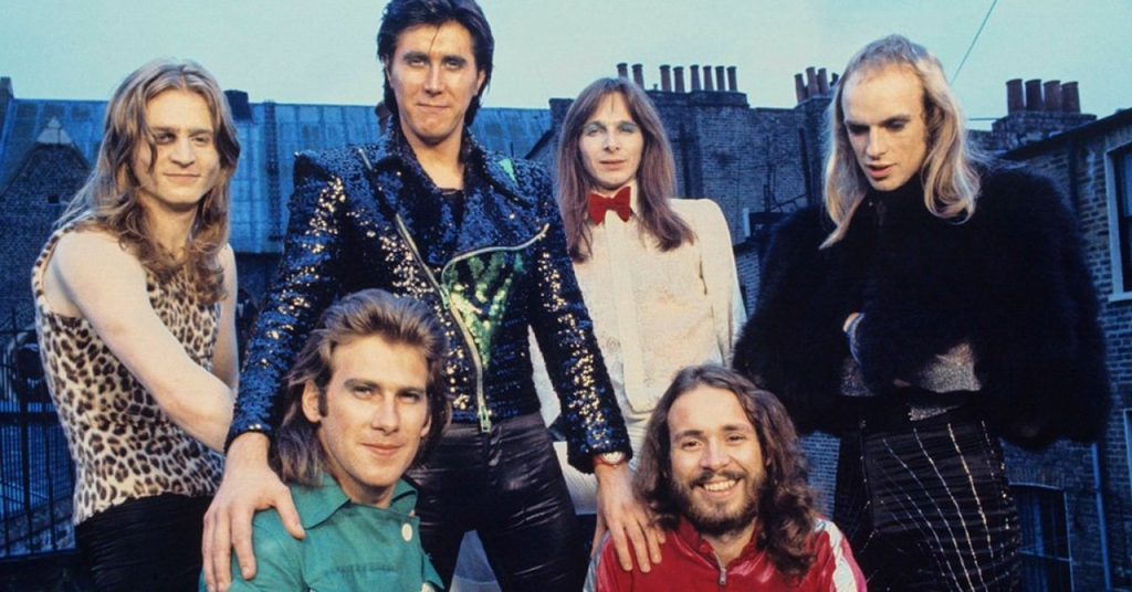 O Roxy Music em 1972. Em pé, da esquerda para a direita: Paul Thompson, Bryan Ferry, Rik Kenton e Brian Eno. Sentados, da esquerda para a direita: Andy Mackay e Phil Manzanera.